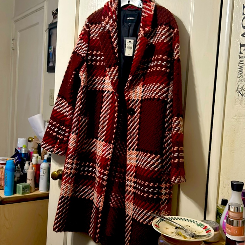 Coat is burgundy, red, white, and peach in color.
